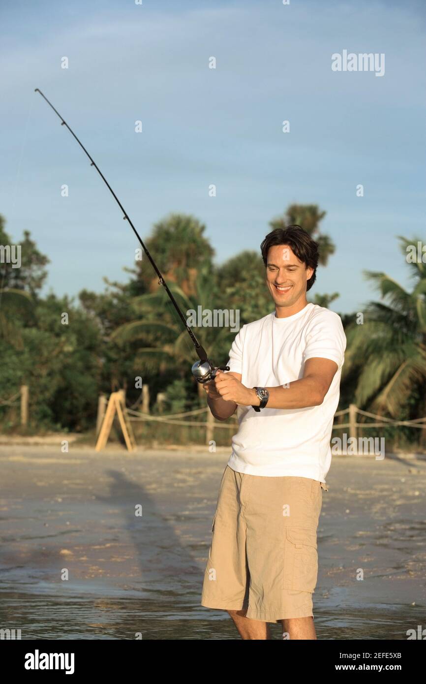 Mid adult man holding a fishing rod Stock Photo - Alamy