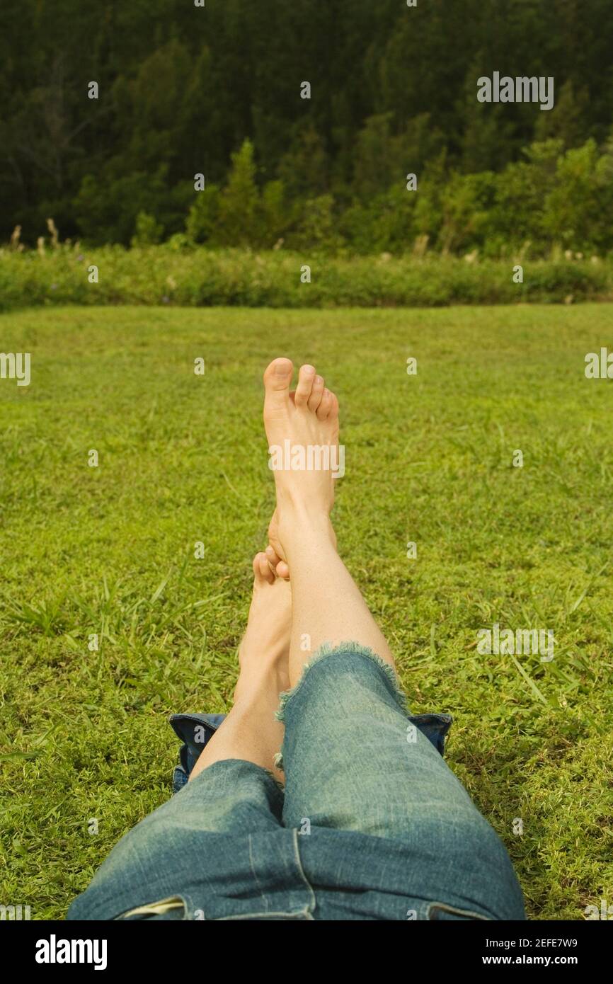 Low section view of a mid adult man lying on the grass Stock Photo - Alamy