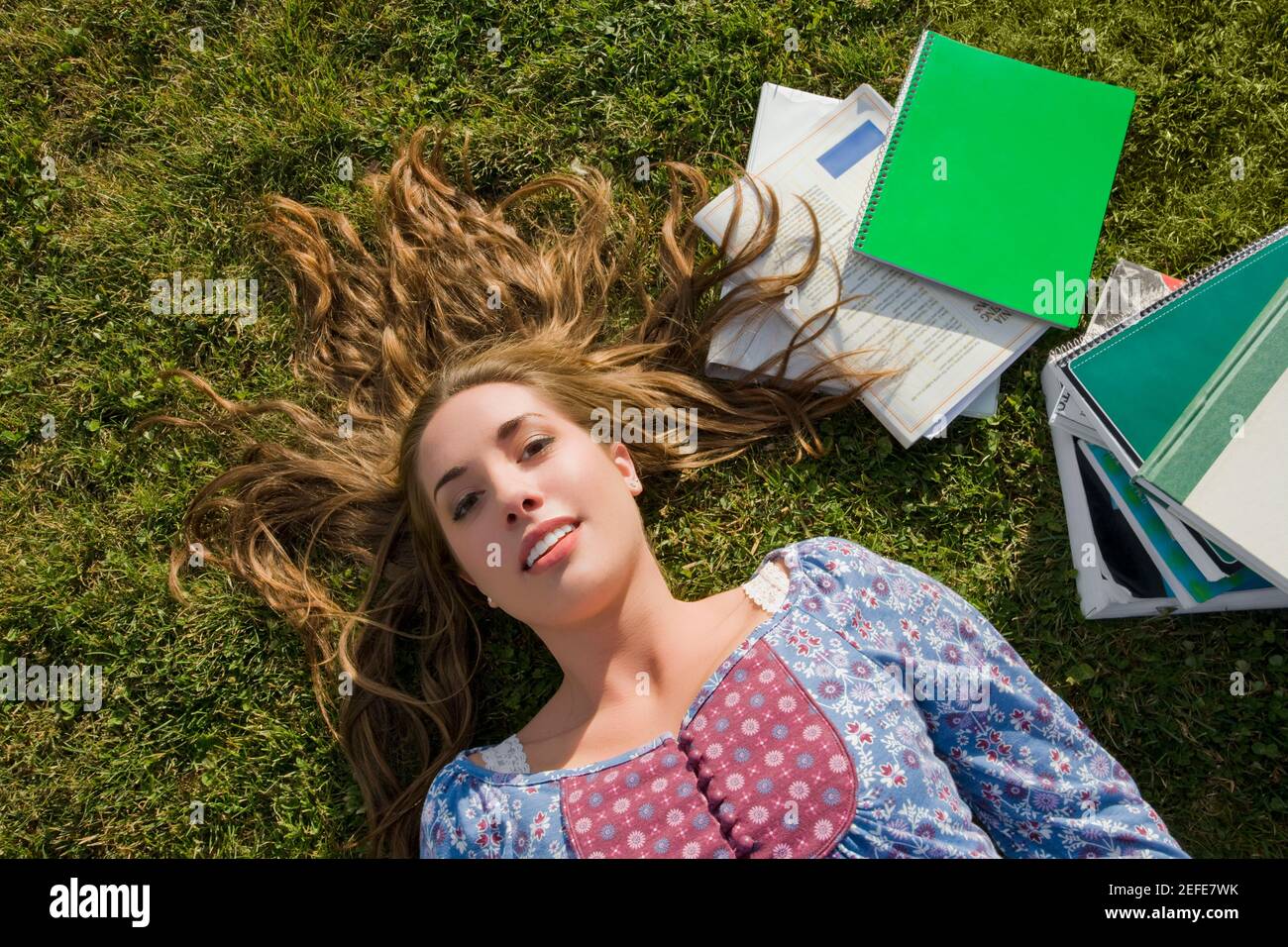 Portrait of a young woman lying on grass Stock Photo - Alamy