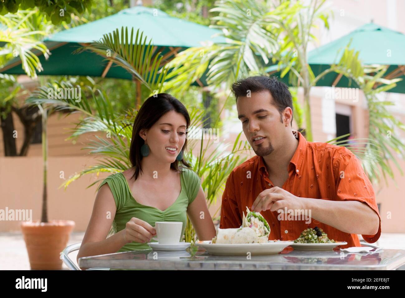 Teenage girl and a mid adult man sitting in a restaurant Stock Photo