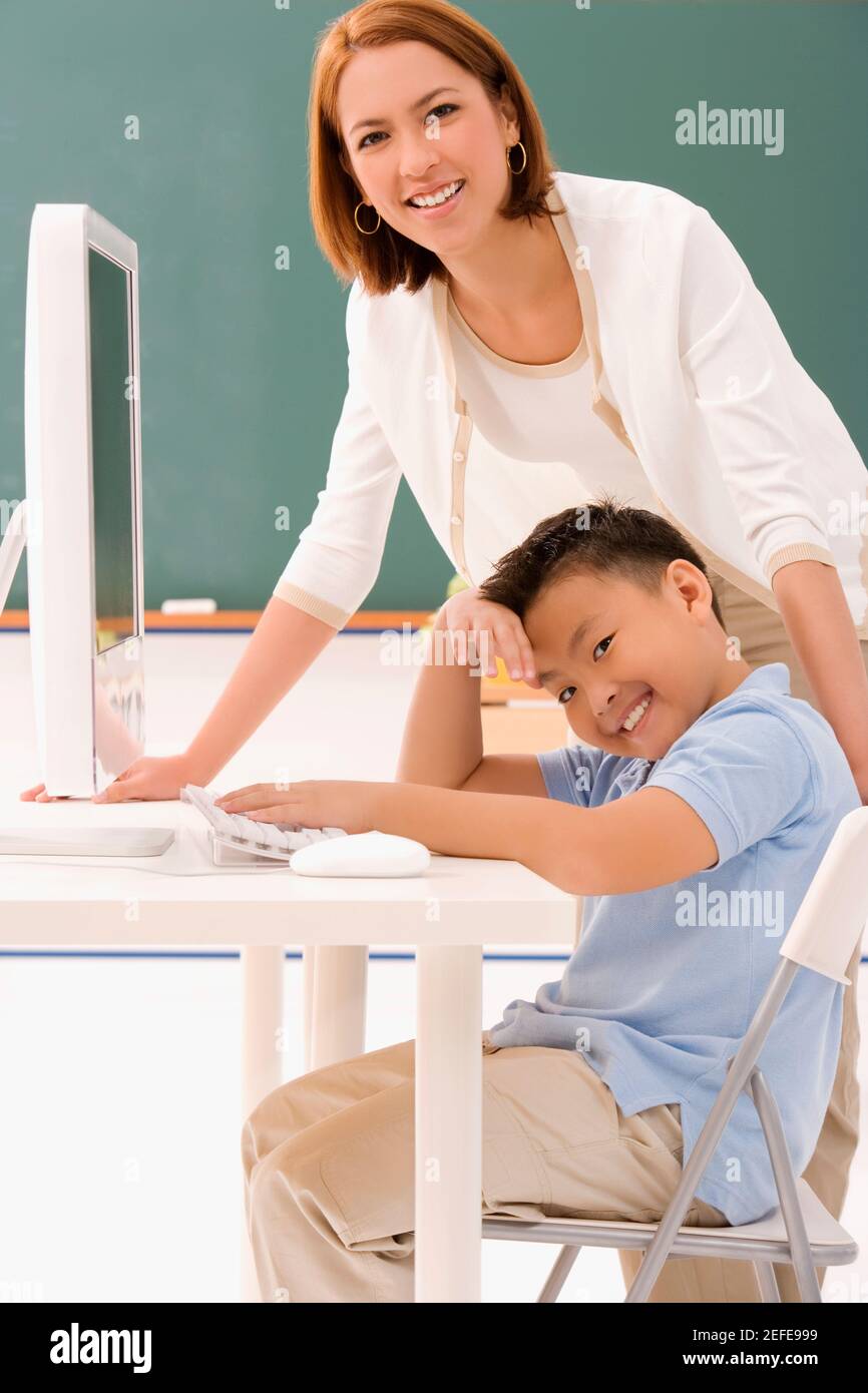 Portrait of a female teacher smiling with her student in a classroom ...