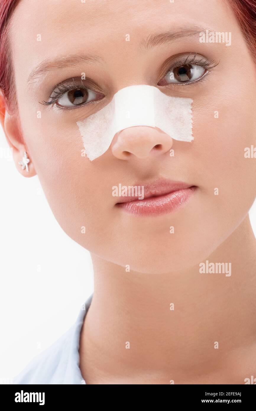 Close up of a female patient with an adhesive bandage on her nose Stock