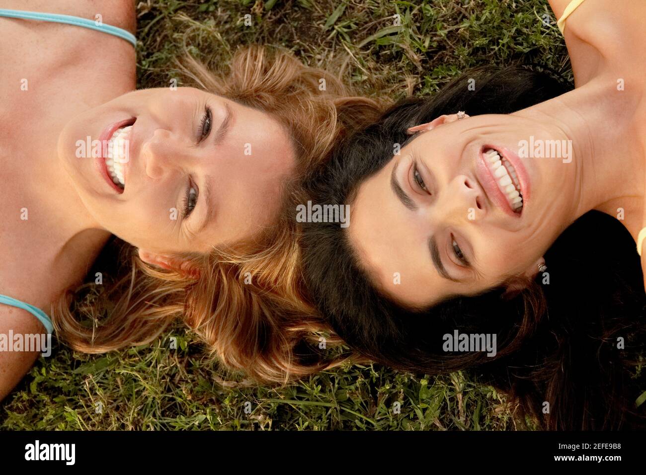 High angle view of a mid adult woman with a mature woman lying on the grass Stock Photo