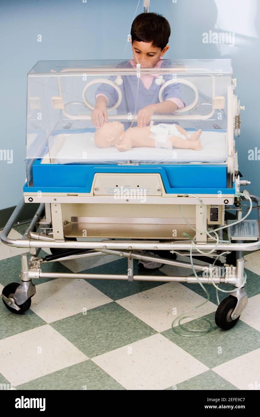 Boy touching a baby boy in an incubator Stock Photo