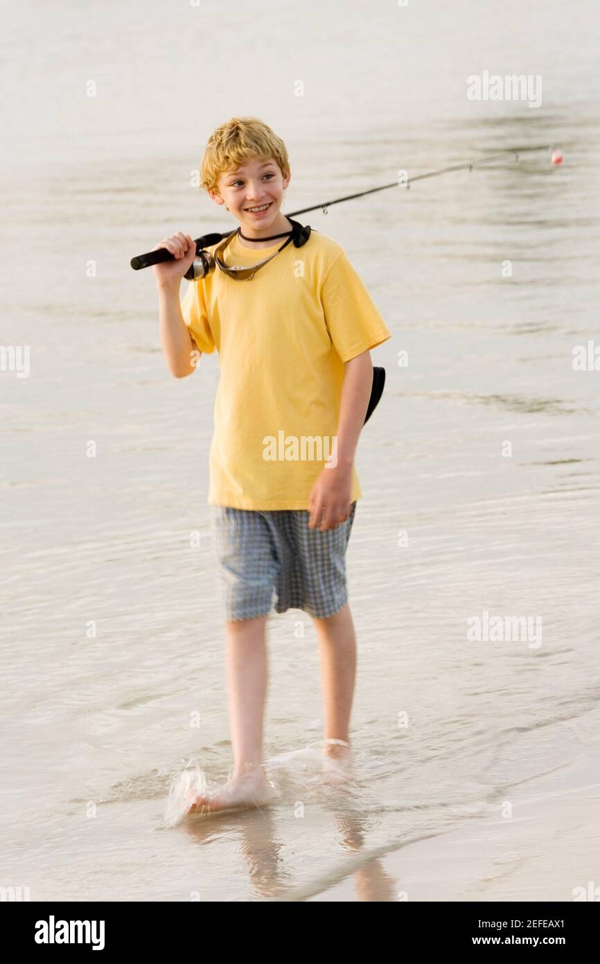 High angle view of a teenage boy walking in a lake with a fishing rod Stock  Photo - Alamy