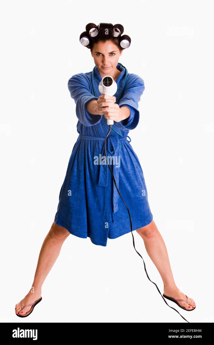 Portrait of a young woman holding a hair dryer Stock Photo