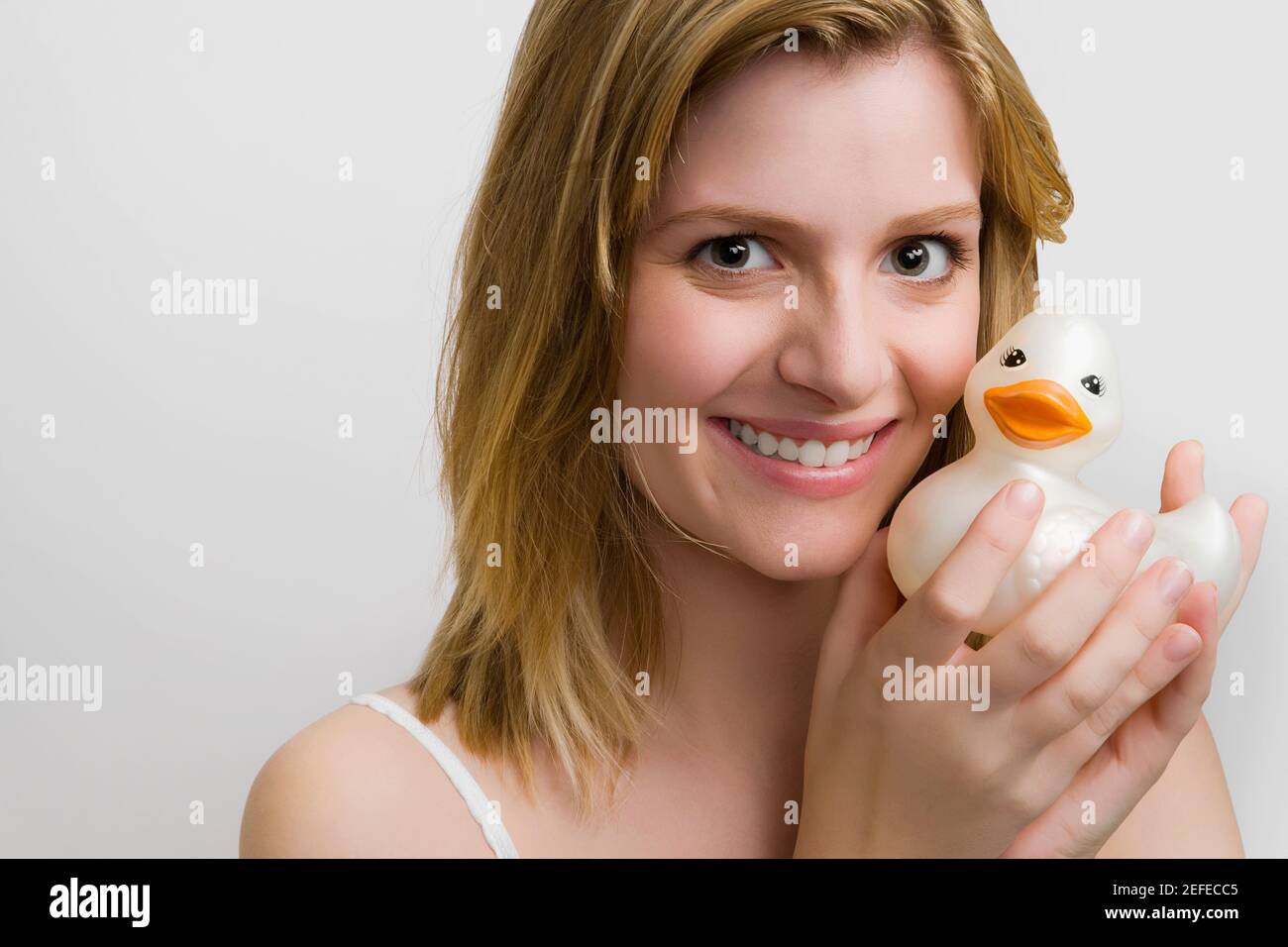 Portrait of a teenage girl holding a rubber duck and smiling Stock Photo