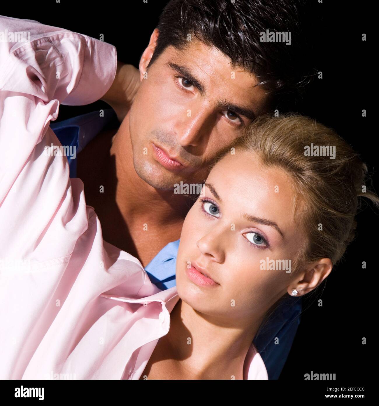 Portrait of a young woman and a mid adult man embracing each other ...