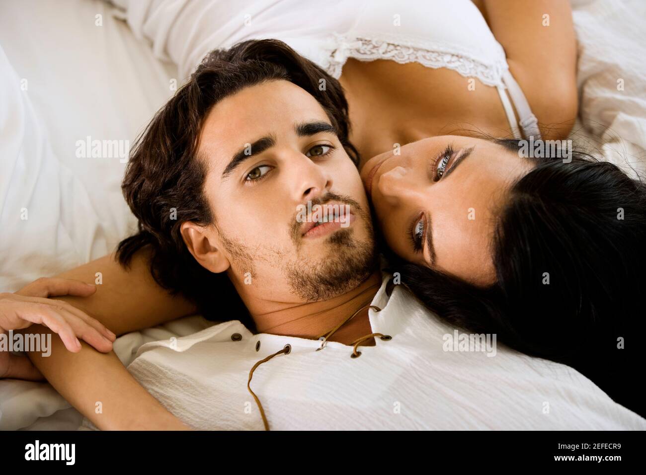 Portrait of a young man lying with a young woman on the bed Stock Photo ...