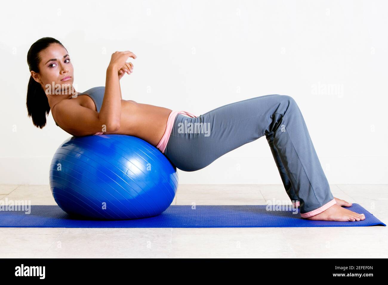 Side profile of a young woman exercising with a fitness ball Stock ...