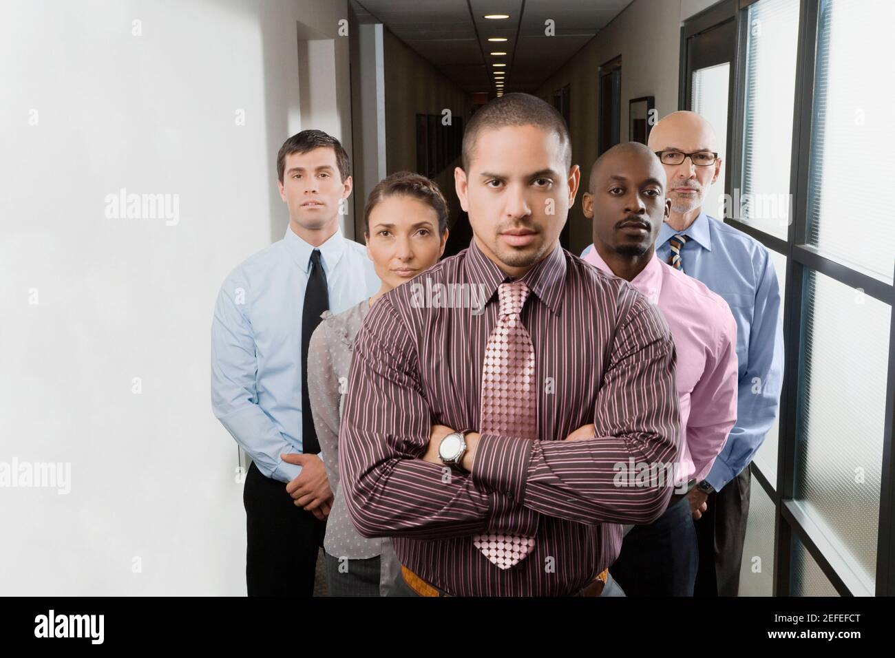 Portrait of business executives standing in a corridor Stock Photo - Alamy