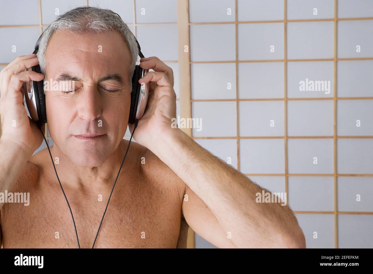 Close_up of a senior man listening to music with headphones Stock Photo