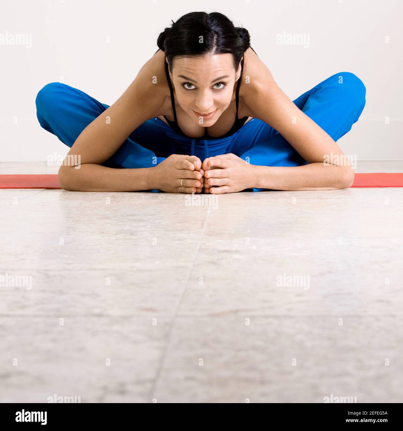 Portrait of a young woman exercising on an exercising mat Stock Photo ...