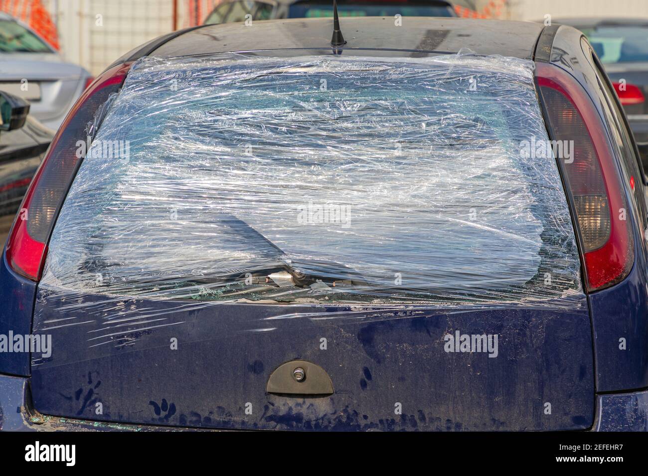 Broken Rear Windscreen at Small Car Covered With Cling Film Stock Photo