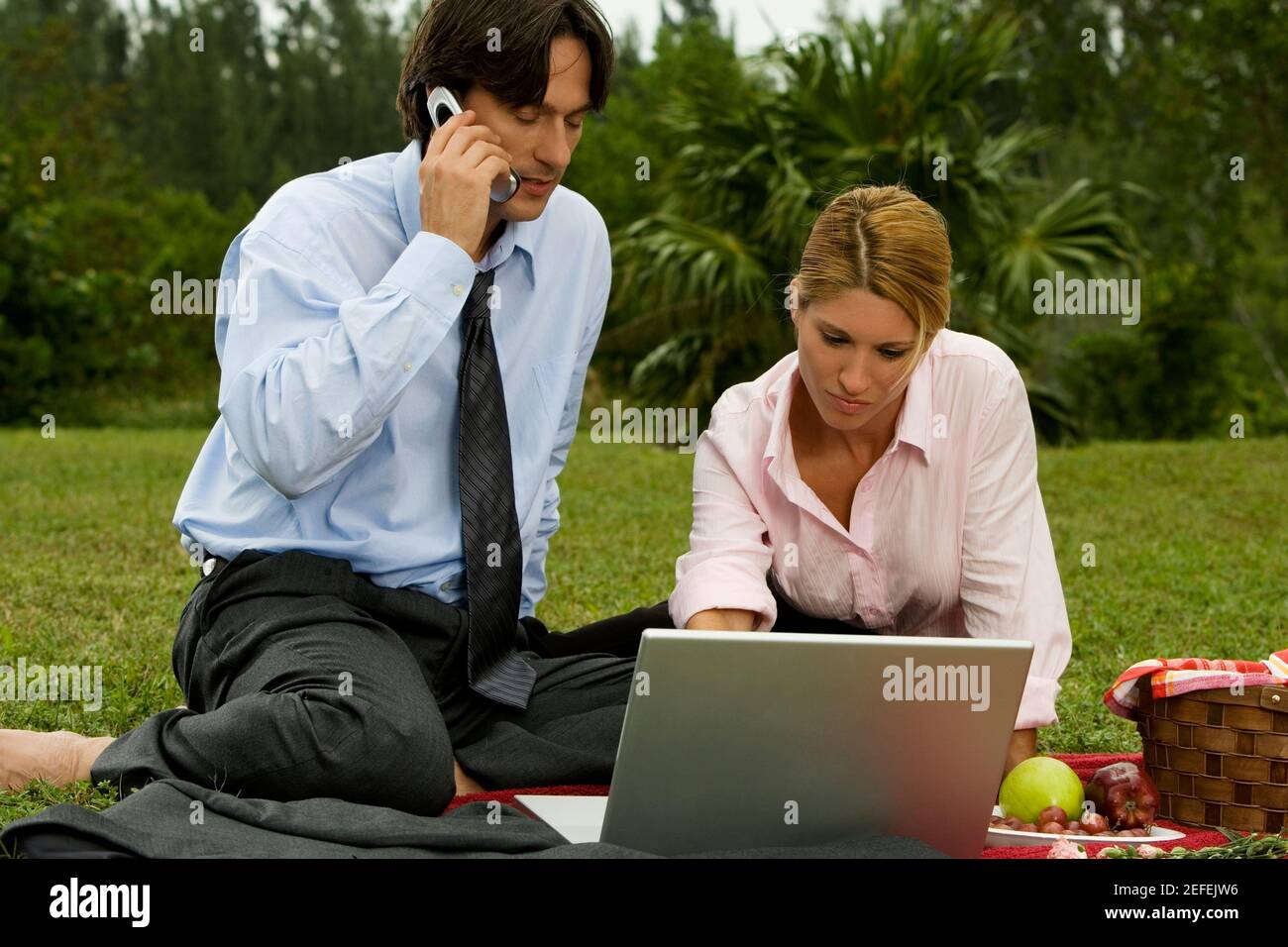 Close-up of a businessman and a businesswoman working on a laptop Stock Photo
