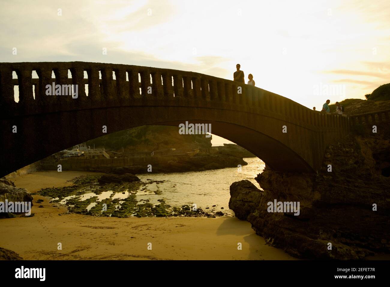 Tourists on the bridge over a beach, Port Des Pecheurs, Biarritz, France Stock Photo