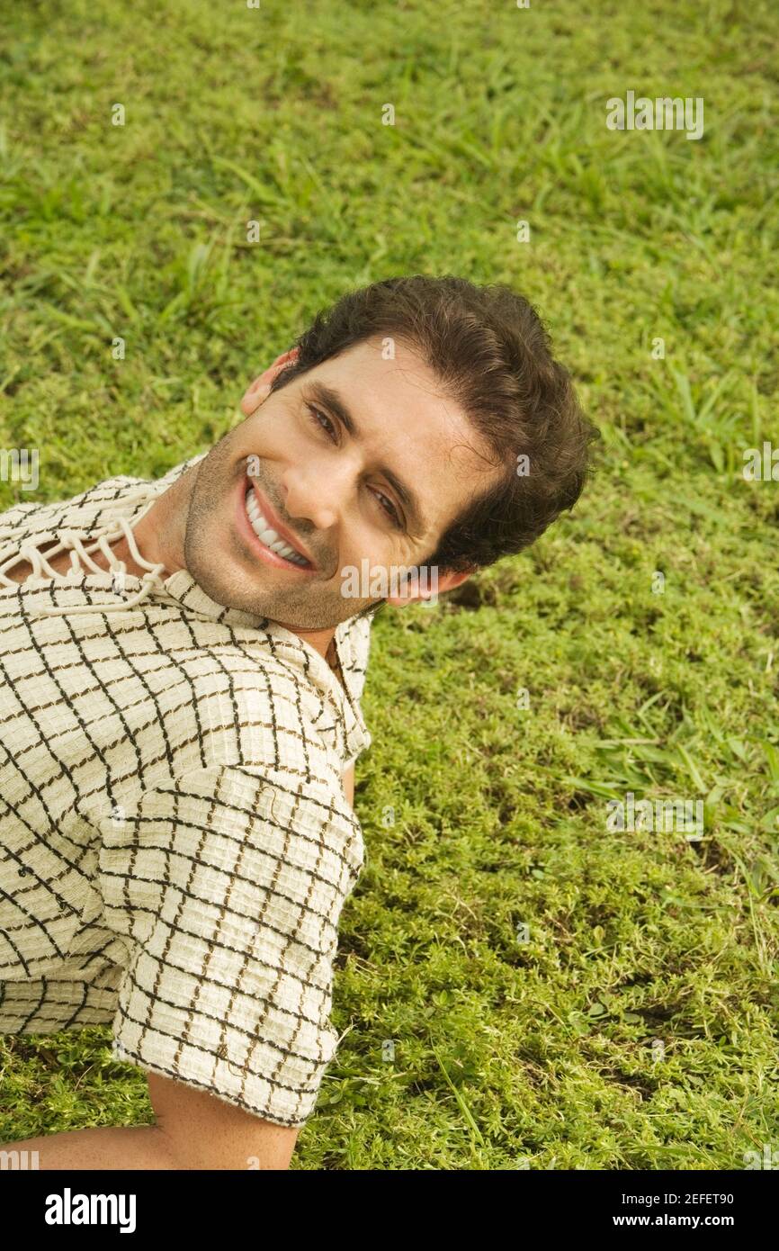 Portrait of a mid adult man lying on the grass Stock Photo - Alamy