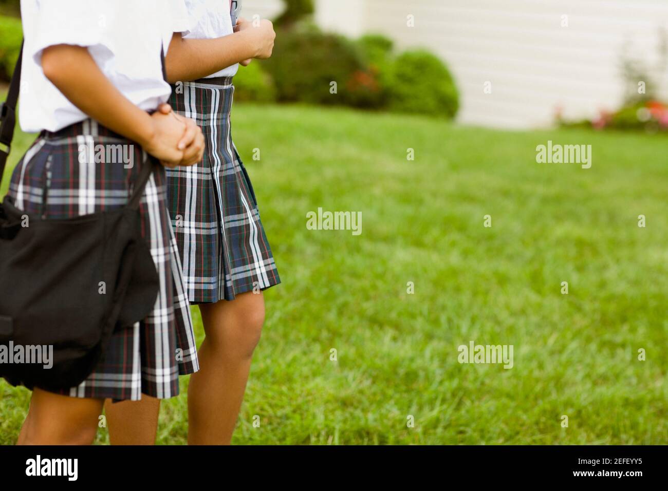 Mid section view of two schoolgirls walking Stock Photo