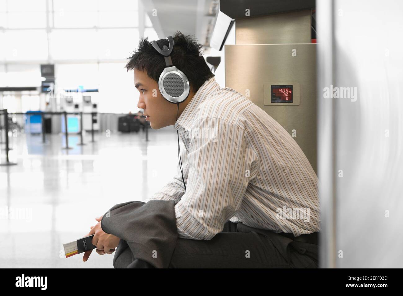 Side profile of a businessman wearing listening to headphones at an