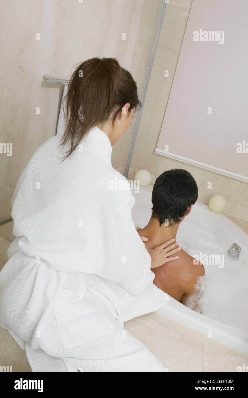 Young woman massaging a mid adult manÅ½s shoulders Stock Photo