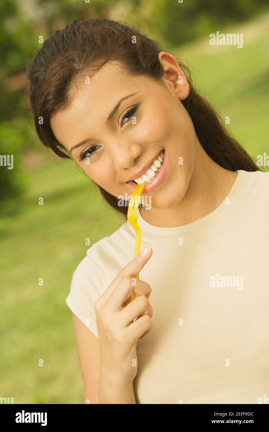 Portrait of a teenage girl holding a fork in her mouth Stock Photo