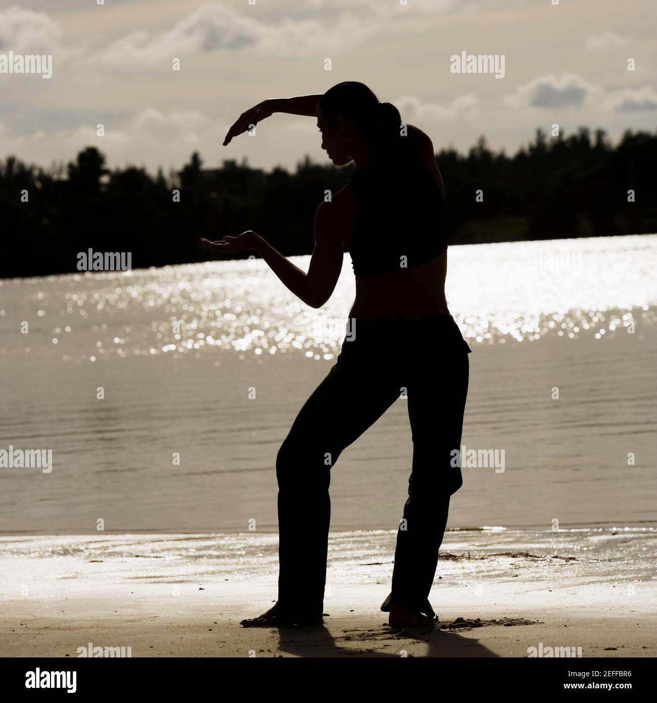 Rear view of a mid adult woman exercising on the beach Stock Photo - Alamy