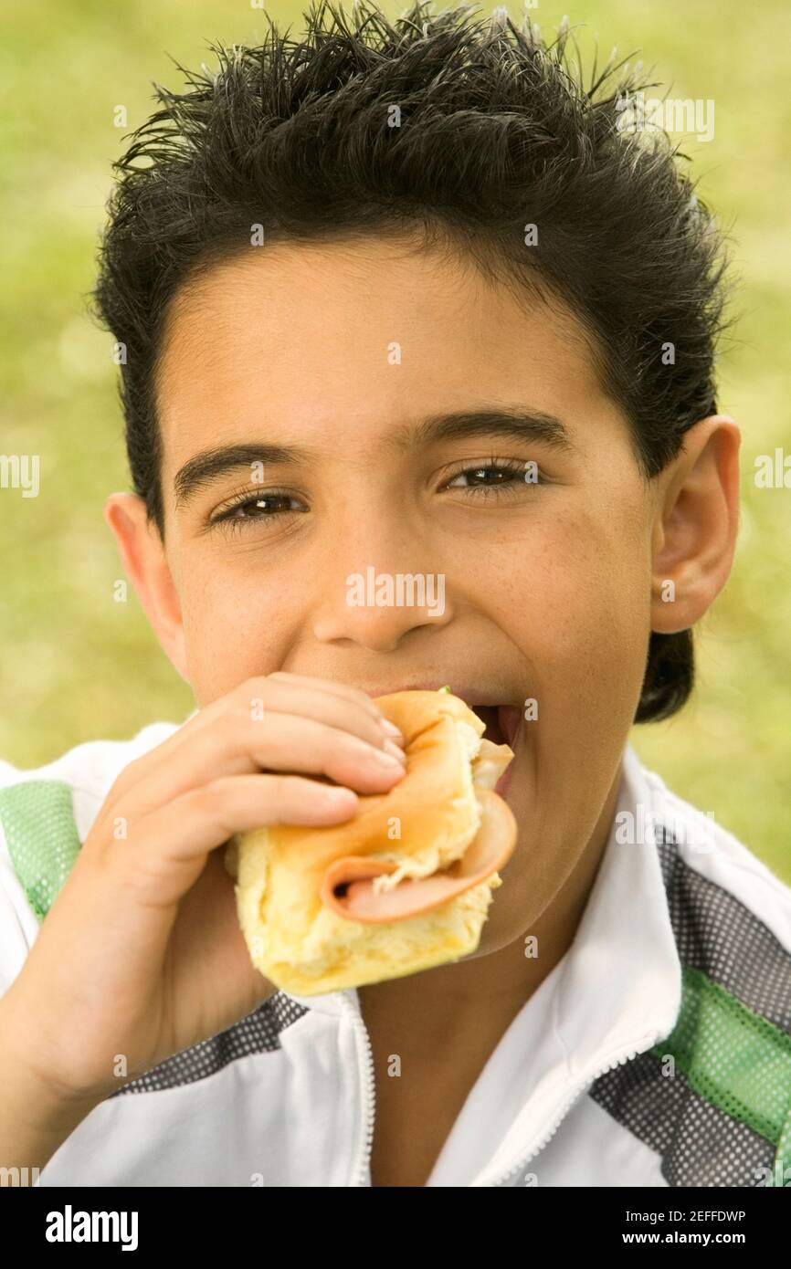 Close-up of a boy eating a burger Stock Photo