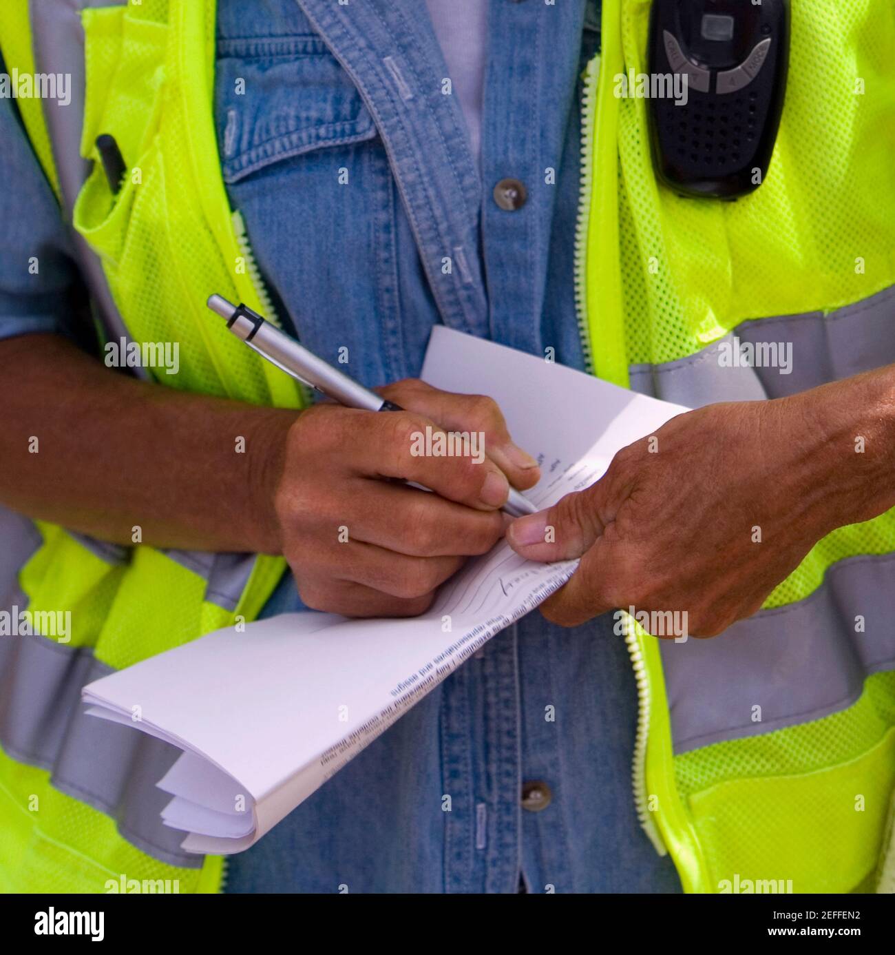Close-up of a construction worker writing on paper Stock Photo