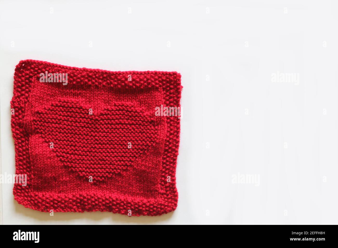 Red knitted square with a heart motif Stock Photo