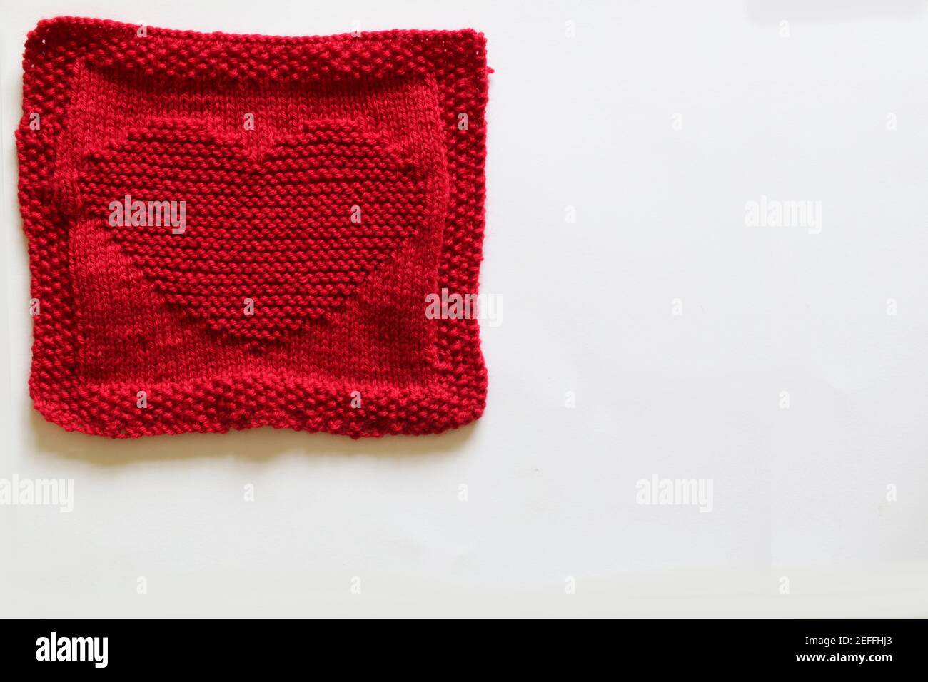 Red knitted square with a heart motif Stock Photo