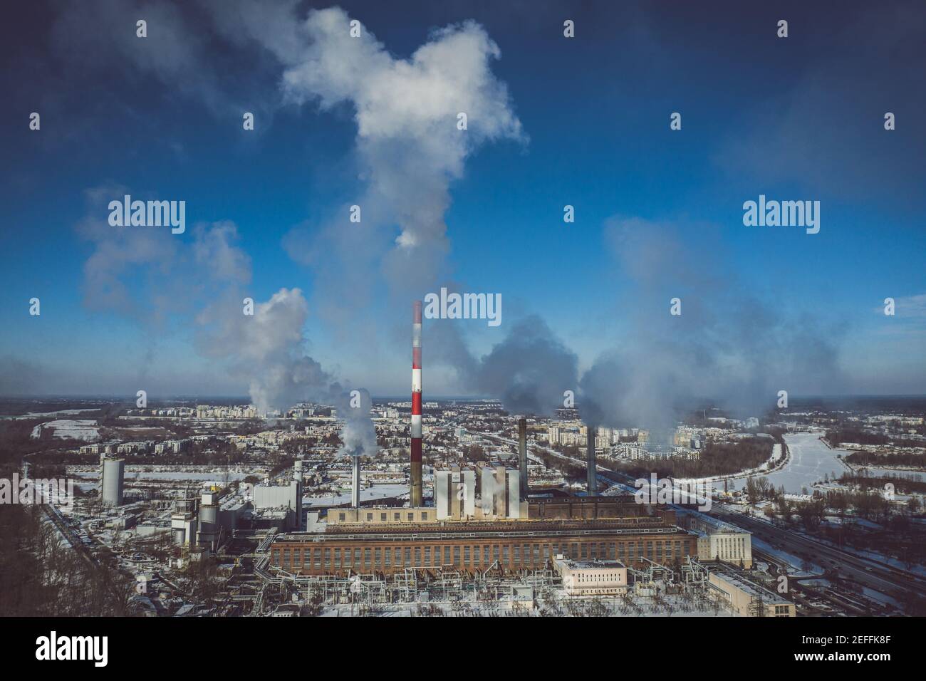 Power plant emitting smoke to the atmosphere against blue sky aerial view Stock Photo