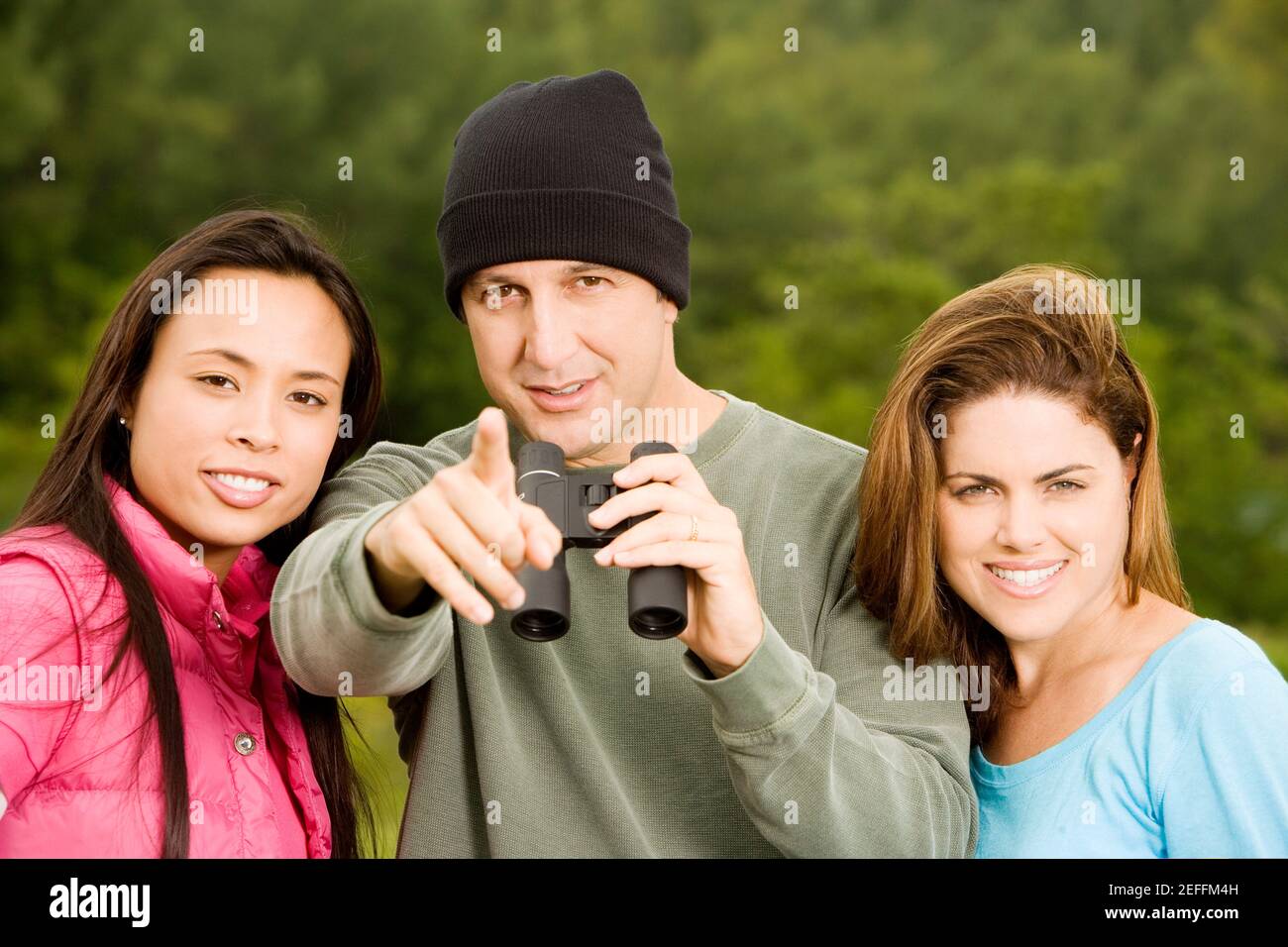 Portrait of a mid adult man and two young women smiling Stock Photo - Alamy