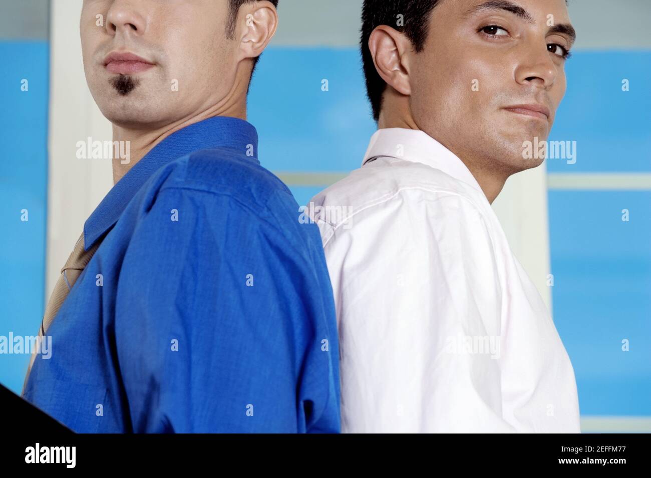 Side profile of two businessmen standing back to back Stock Photo - Alamy