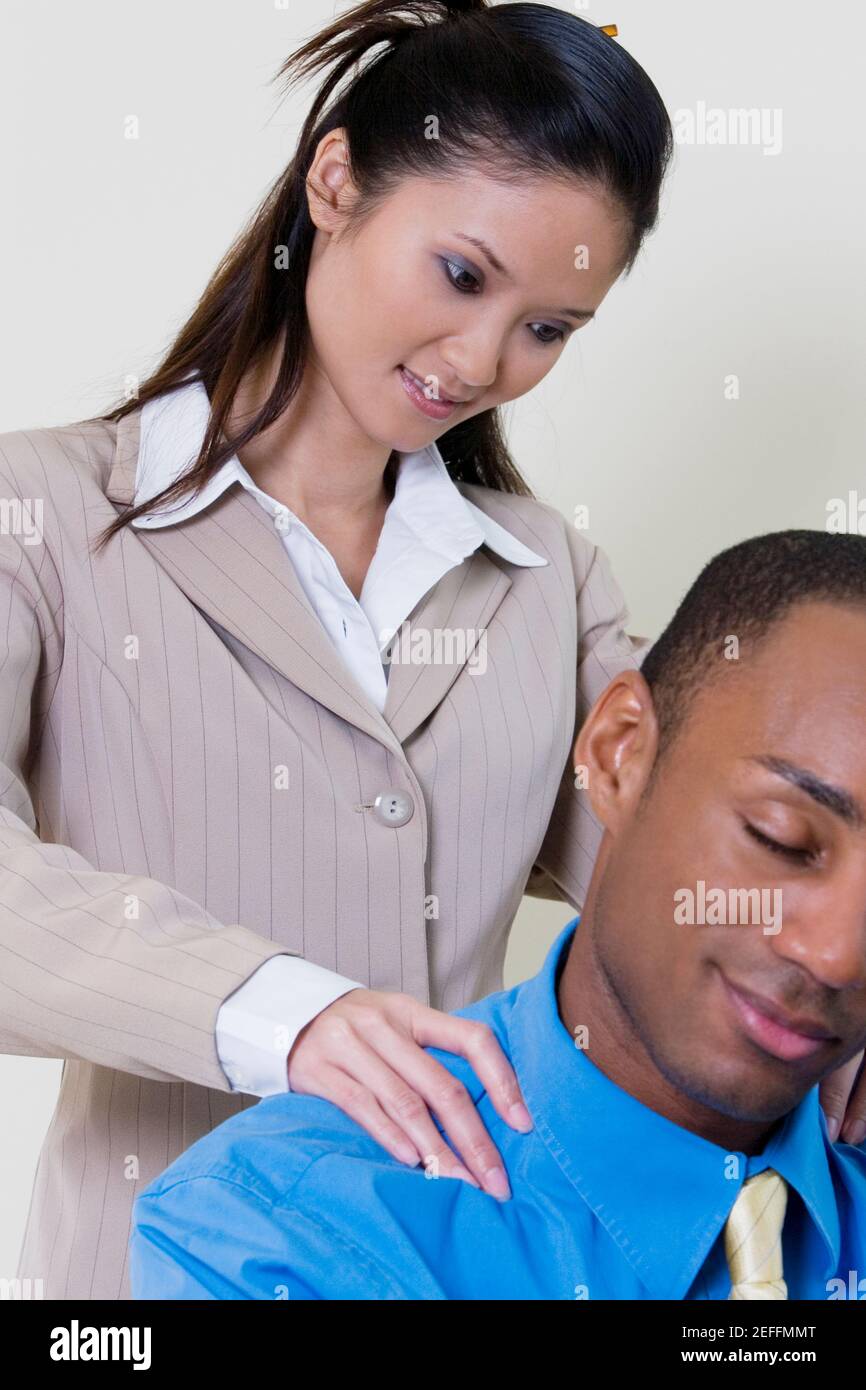 Close-up of a businesswoman massaging a businessmanÅ½s shoulders Stock Photo