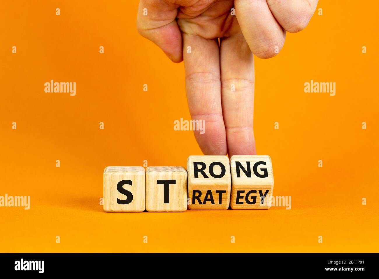 Strong strategy symbol. Businessman turns wooden cubes with words 'strong strategy'. Beautiful orange background, copy space. Business and strong stra Stock Photo