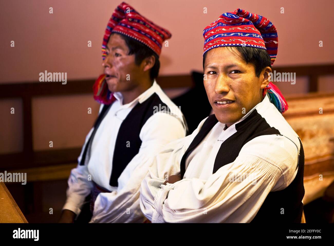 Close-up of two young men taking part in a wedding ceremony, Taquile Island, Lake Titicaca, Puno, Peru Stock Photo