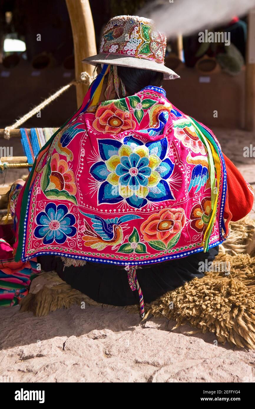 Rear view of a woman weaving in a loom, Aguanacancha, Peru Stock Photo