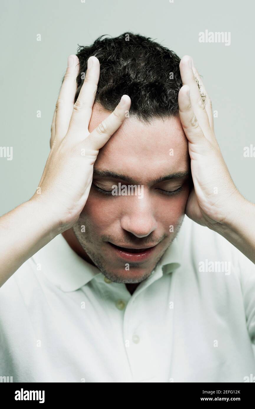 Close up of a mid adult man with his head in his hands Stock Photo
