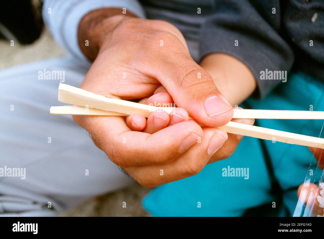 Close-up of a father teaching his son the use of chopsticks, Okinawa, Japan Stock Photo