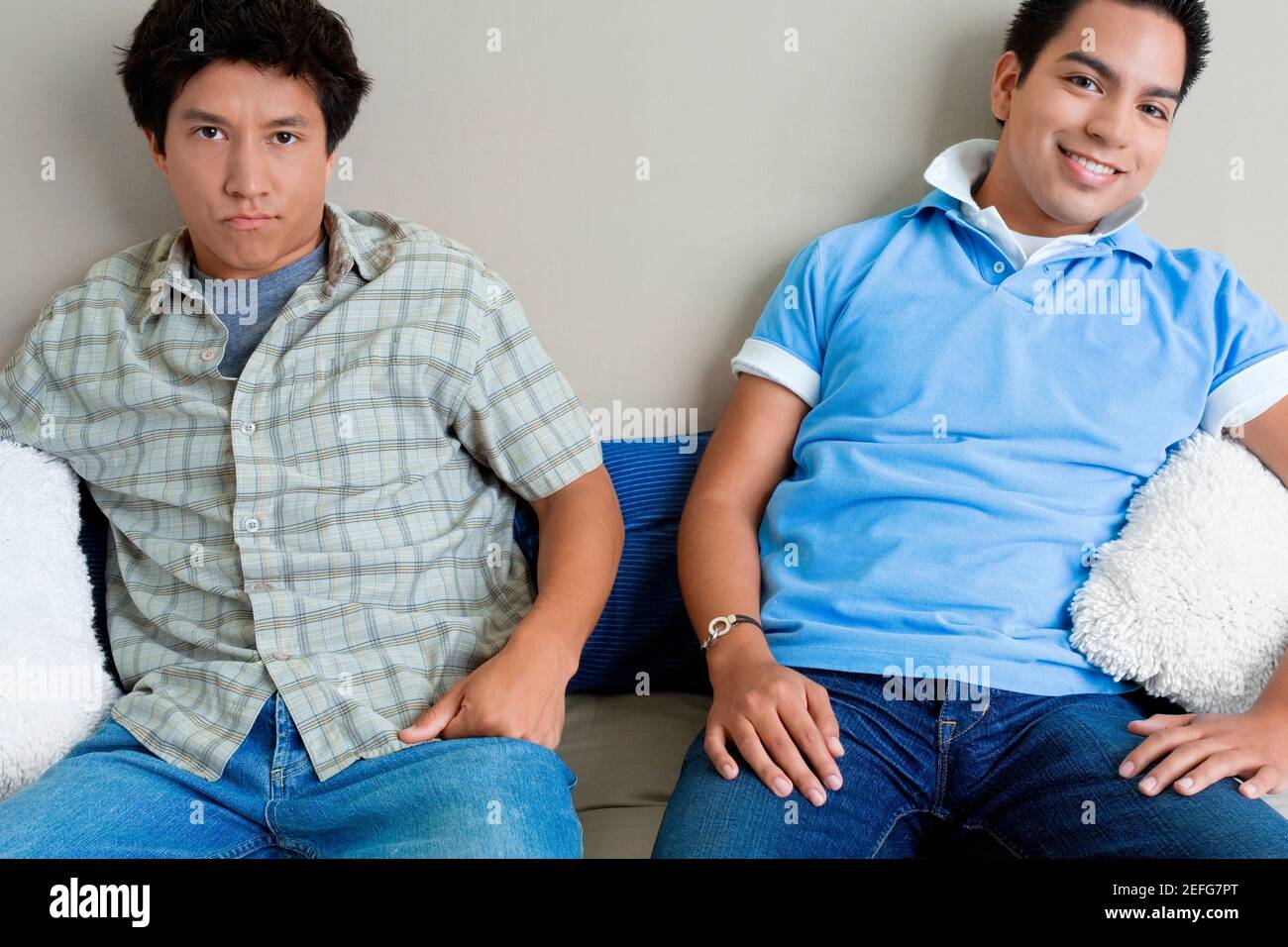 Two young men sitting on a couch Stock Photo