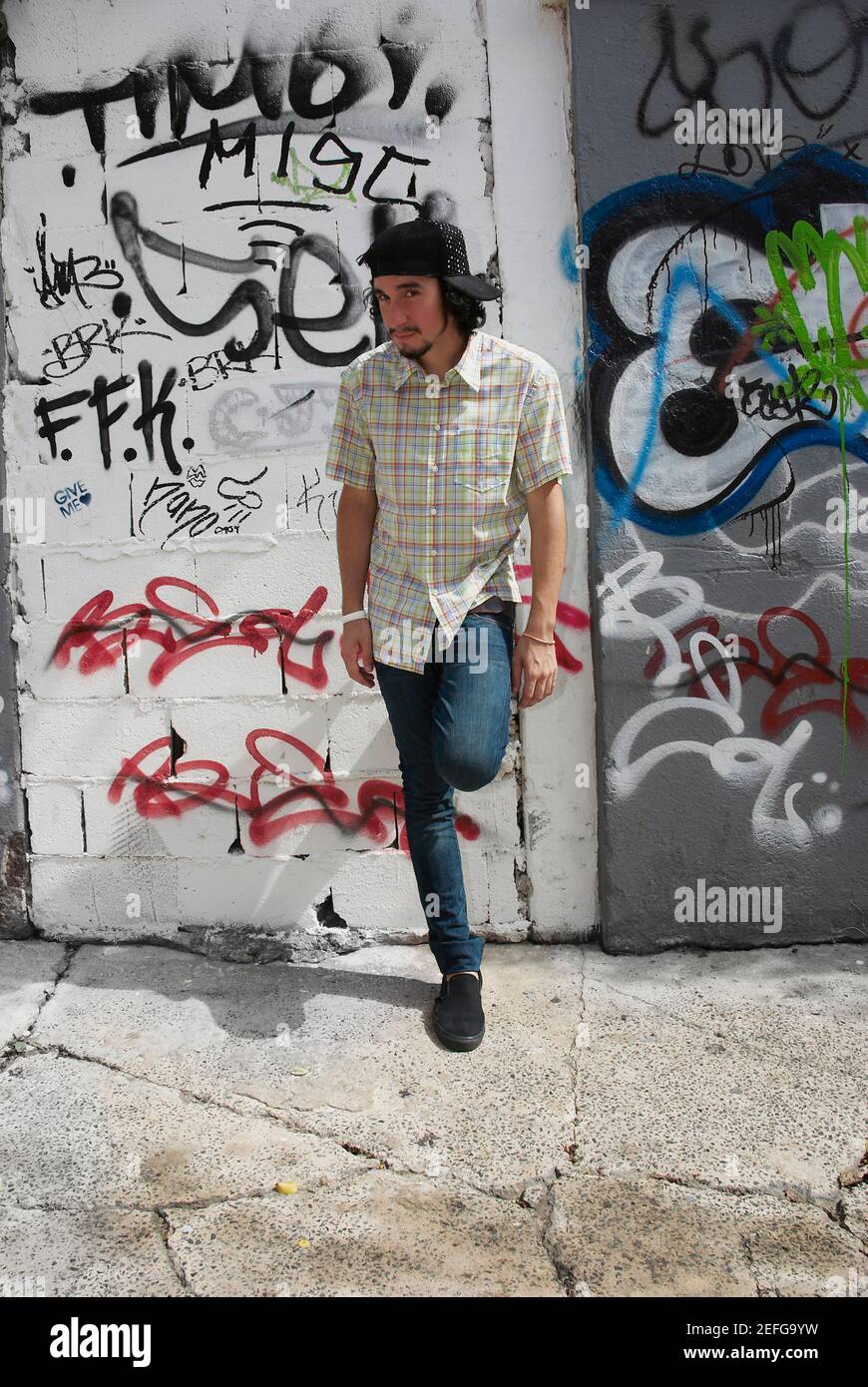 Young man leaning against a wall Stock Photo