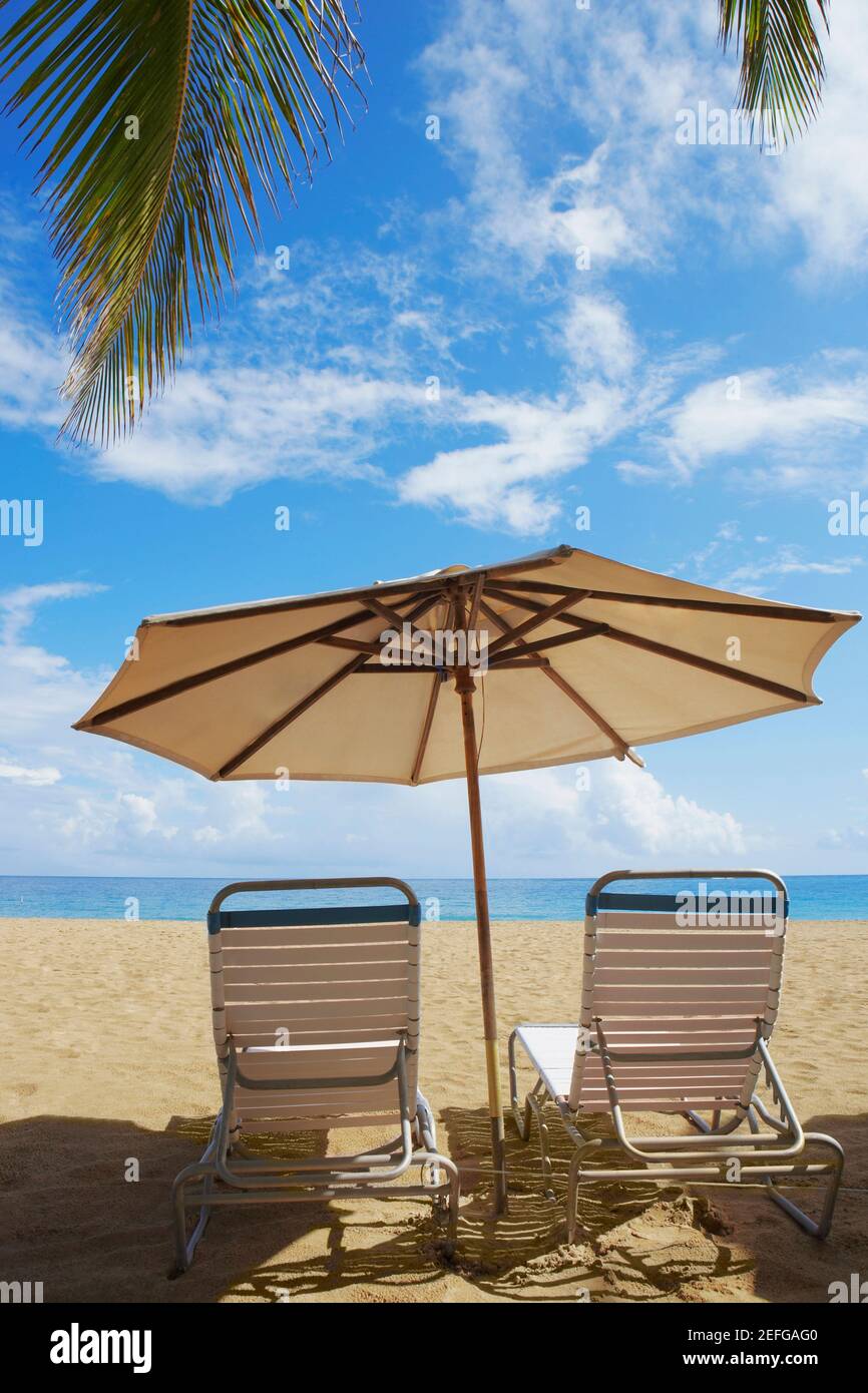 Two outdoor chairs and a beach umbrella on the beach, Ocean Park, El Condado, San Juan, Puerto Rico Stock Photo