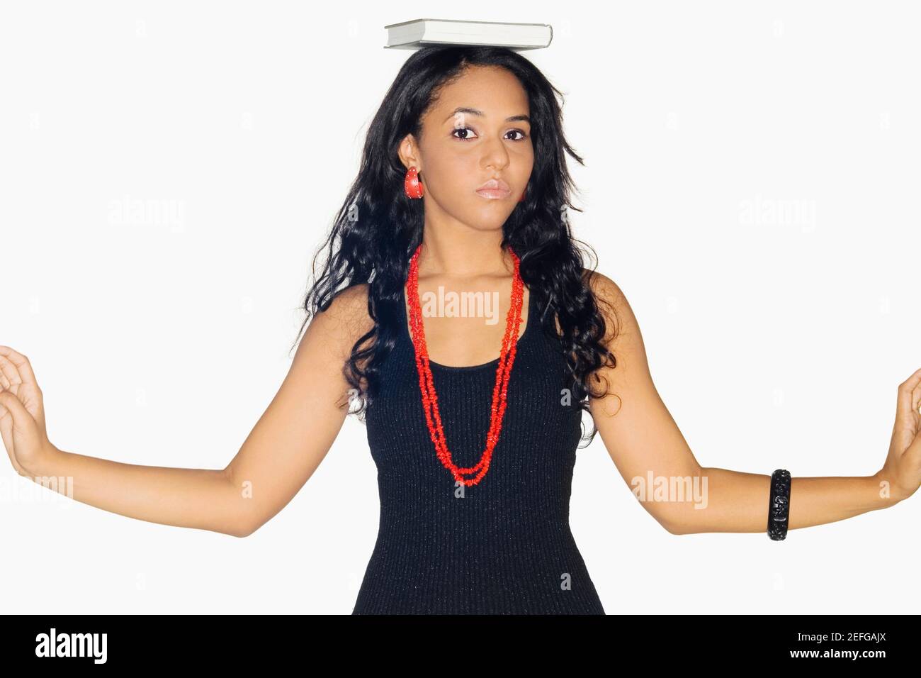 Portrait of a teenage girl with a book on her head Stock Photo - Alamy