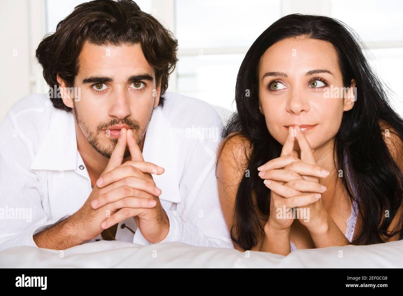 Portrait of a young man and a young woman lying on the bed Stock Photo ...