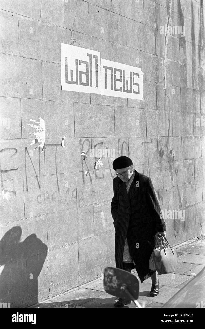 UK, West London, Notting Hill, 1973. Rundown & dilapidated large four-story houses are starting to be restored and redecorated. Grafitti says 'Rent Revolt' on a wall used for communication to local people. Stock Photo