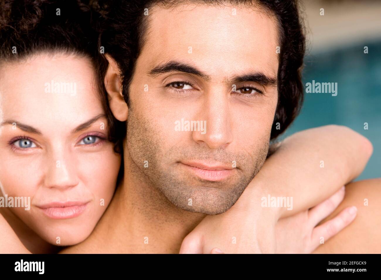 Portrait of a young woman embracing a mid adult man from behind Stock ...