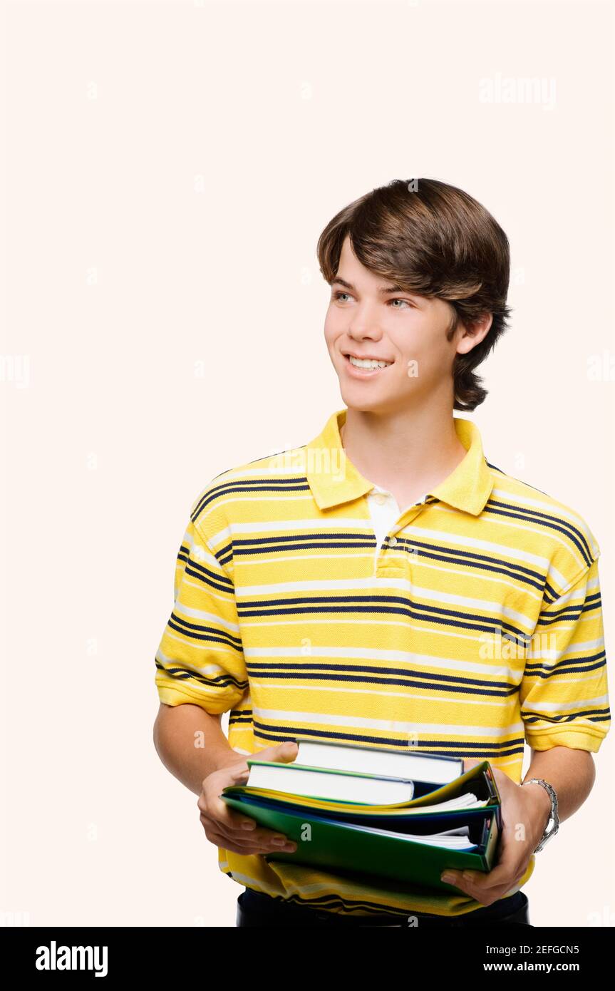 Close-up of a teenage boy holding books and ring binders Stock Photo ...
