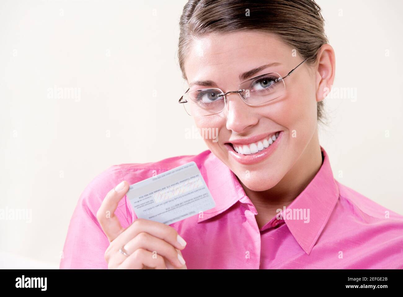 Portrait of a young woman holding a credit card Stock Photo