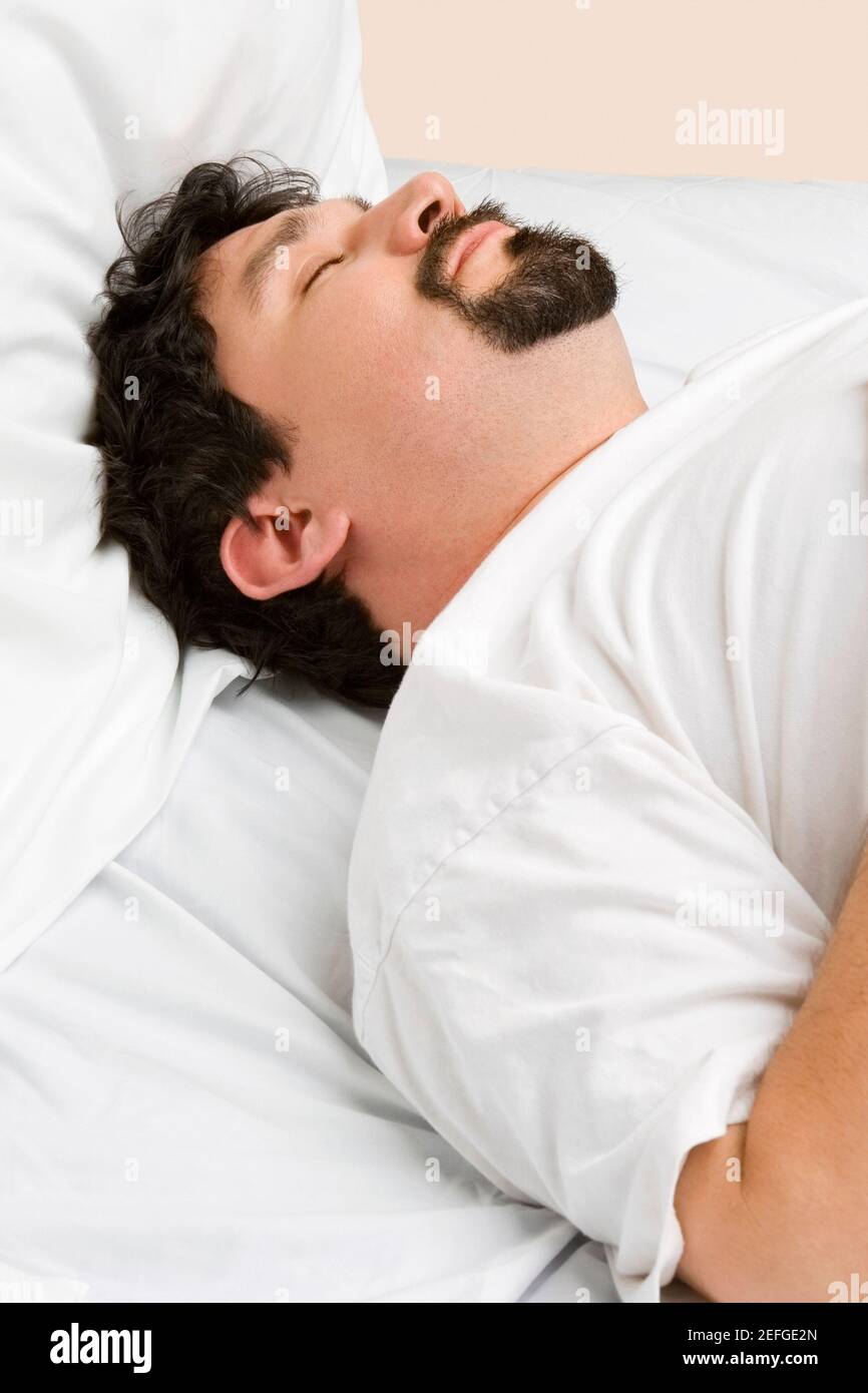Mid adult man sleeping on the bed Stock Photo - Alamy