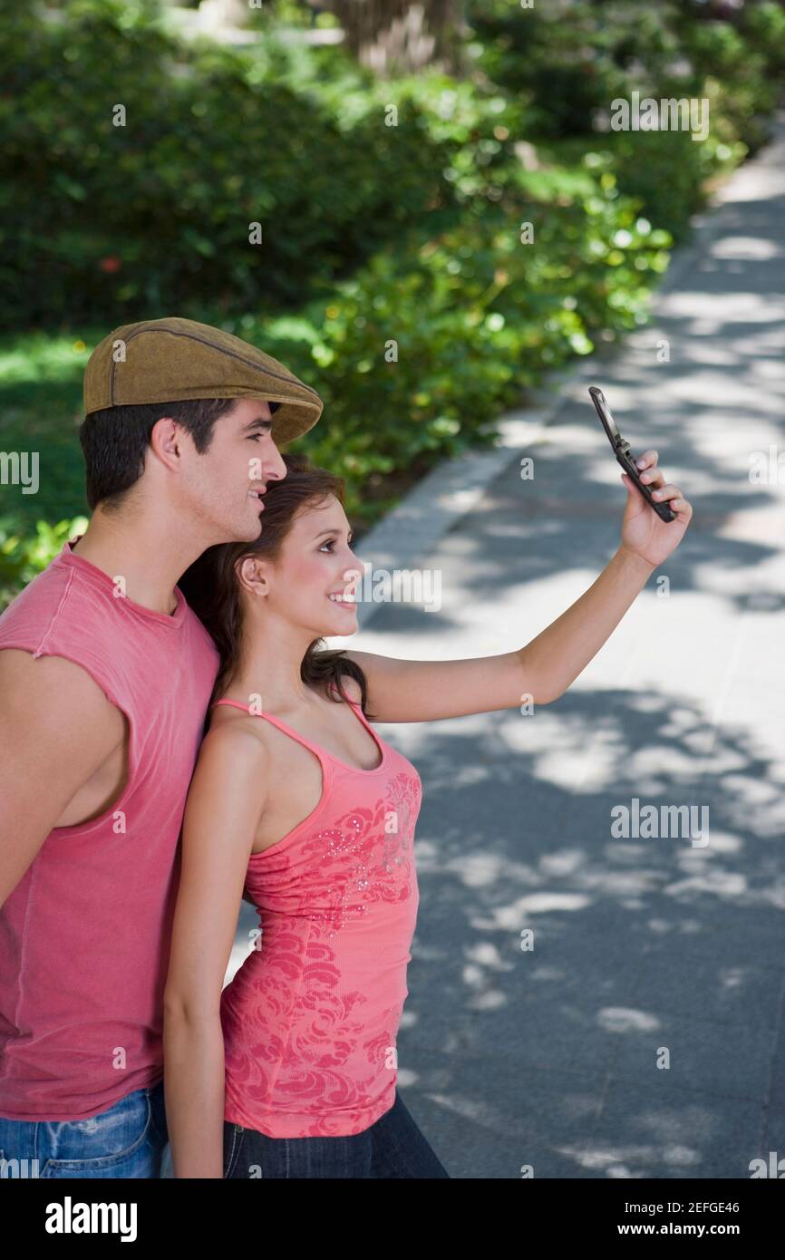 Young couple taking a photograph of themselves with a mobile phone Stock Photo
